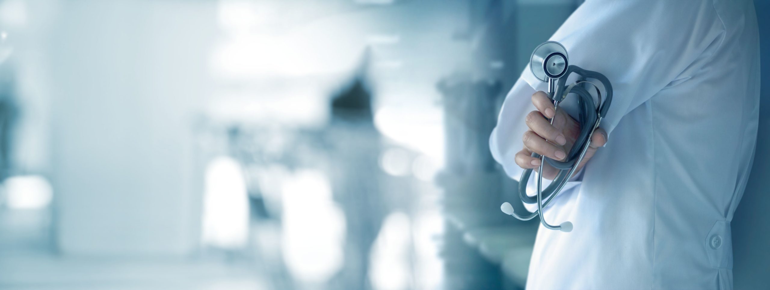 Doctor with stethoscope in hand on hospital background, medical and medicine concept